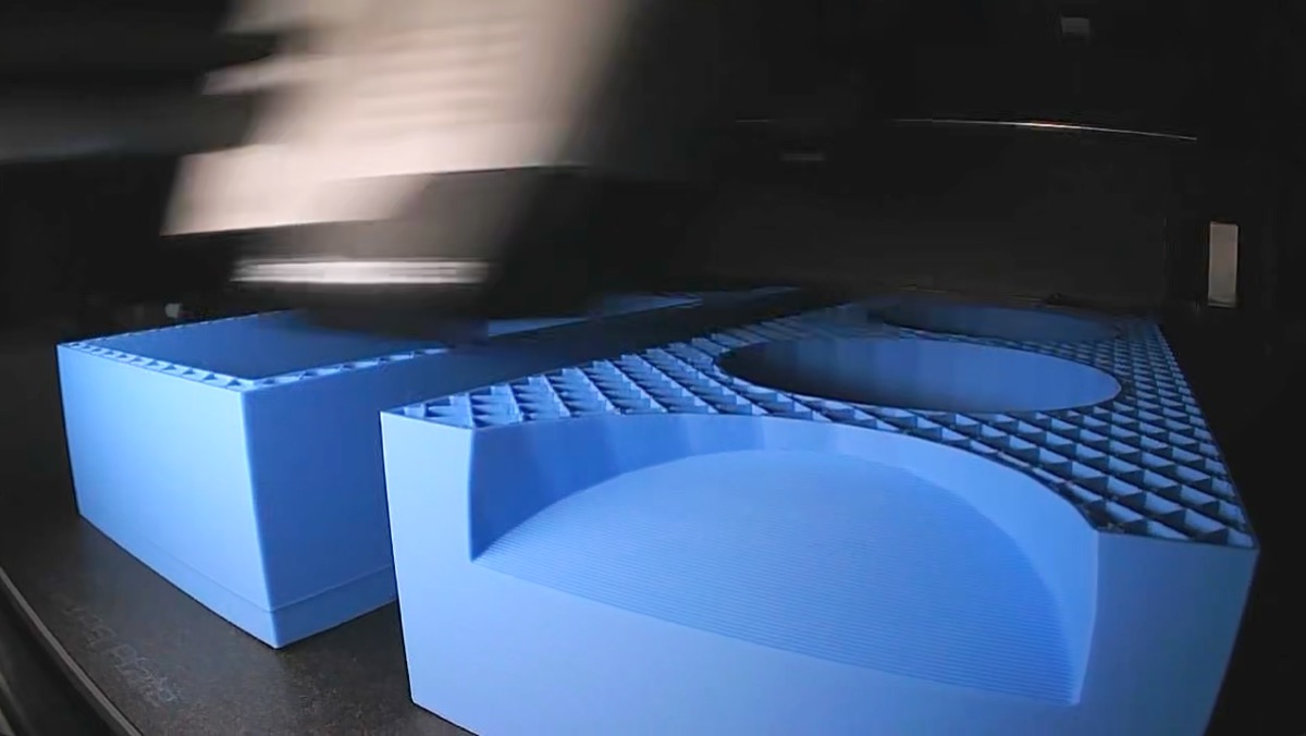 Finished blue 3D-printed mortar-rack spacer blocks resting on the printer bed